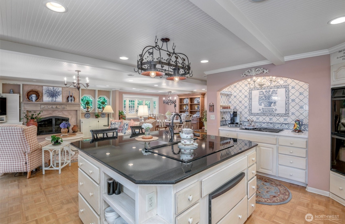Open chef's kitchen with granite island and family room with fireplace